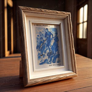 May include: A wooden picture frame with a white mat and a blue and white abstract painting inside. The painting depicts figures in a swirling blue background. The text "I will play... You will dance" is printed below the painting.