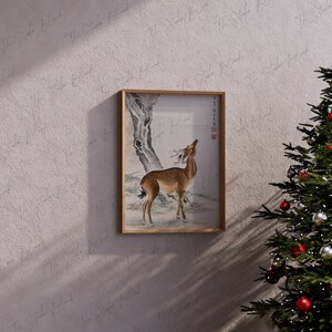 May include: A framed black and white ink drawing of a deer standing in a forest. The deer is looking up at a tree branch. The drawing is on a white background.