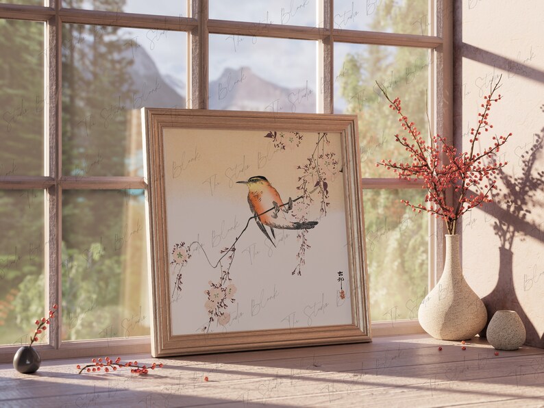 May include: A framed print of a bird perched on a branch of a flowering tree. The bird is orange, yellow, and brown with a long tail. The background is a light beige color. The print is in a wooden frame with a white mat.