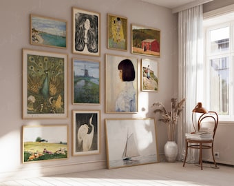 May include: A gallery wall with various framed artwork, including a peacock, a windmill, a sailboat, a woman with long hair, and a girl with dark hair. The wall is painted a light beige color and the frames are all a light wood color.