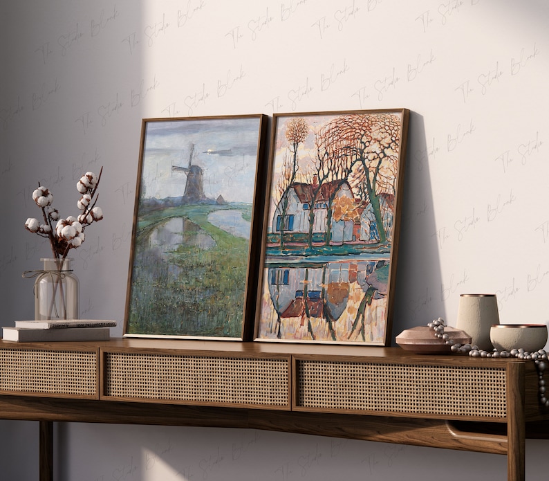 Peut inclure: Deux tableaux encadr&eacute;s accroch&eacute;s &agrave; un mur au-dessus d'une console en bois. Le tableau de gauche repr&eacute;sente un moulin &agrave; vent dans un champ avec un reflet dans un &eacute;tang. Le tableau de droite montre une maison avec un toit rouge et des arbres refl&eacute;t&eacute;s dans un &eacute;tang.