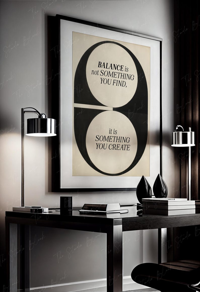 May include: Black and white graphic print with the text "BALANCE is not SOMETHING YOU FIND, it is SOMETHING YOU CREATE". The print is framed and hanging on a wall above a black desk.