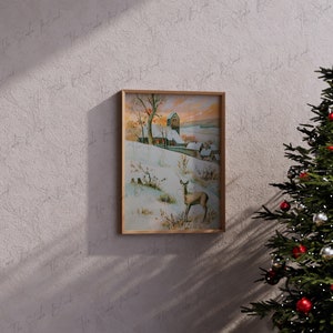 May include: A framed vintage illustration of a snowy winter scene with a small village, a deer, and a church in the distance. The illustration is in a wooden frame and is hanging on a wall.