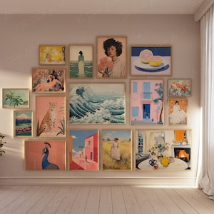 Puede incluir: Una pared de galería con una variedad de obras de arte enmarcadas, que incluyen una pintura de olas, un retrato de una mujer, un bodegón con fruta y una pintura de paisaje. La pared está pintada de color rosa claro y los marcos son todos dorados.