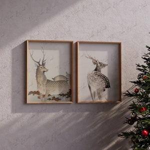 Peut inclure: Deux illustrations encadrées de cerfs dans un style minimaliste. Les cerfs sont représentés dans une palette de couleurs brun clair et gris sur un fond blanc. Les cadres sont en bois clair.