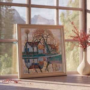 May include: A framed painting of a house with trees and a reflection in the water. The painting is in a light wood frame and is hanging on a wall. There are red berries in a vase on the windowsill.