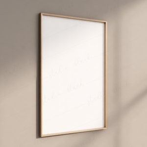 May include: A gold-colored frame with a white background. The frame is hanging on a beige wall.