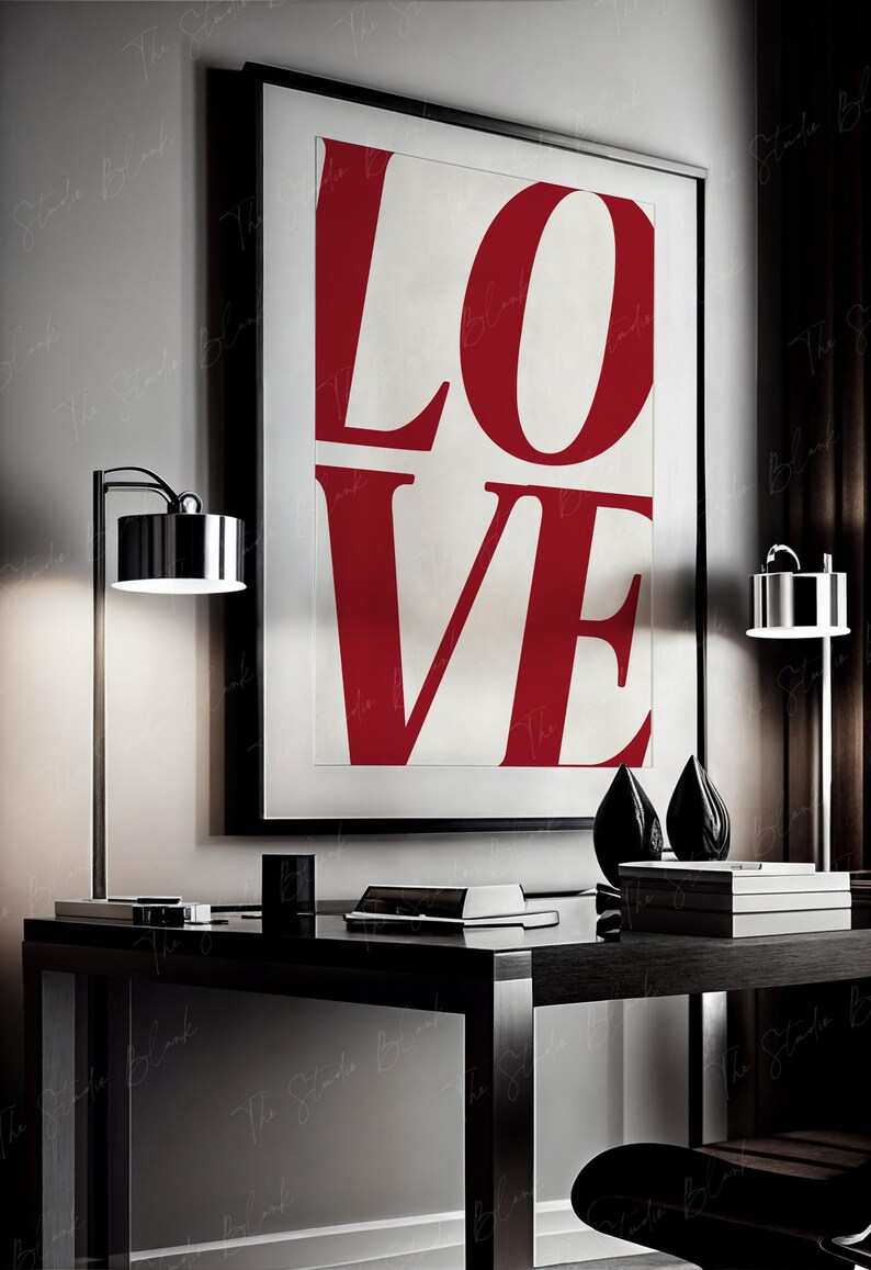 May include: A black framed poster with the word "LOVE" in large, bold, red letters on a white background. The poster is hanging on a wall above a black desk with a lamp on each side.