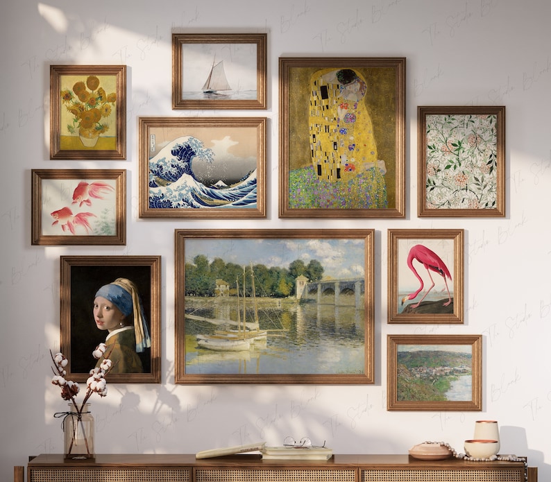 May include: A collection of framed artwork on a white wall. The artwork includes a painting of a wave, a painting of a couple kissing, a painting of a flamingo, a painting of sunflowers, a painting of fish, a painting of a boat, and a painting of a floral pattern.