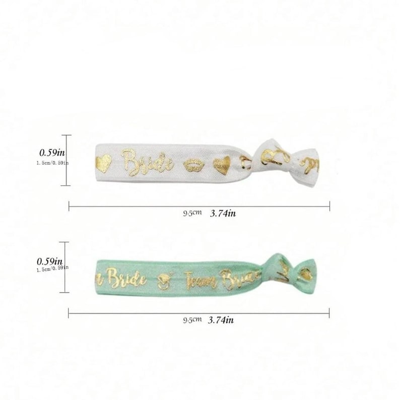 May include: Two hair ties with gold lettering. The first hair tie is white with the word "Bride" and gold hearts and lips. The second hair tie is light green with the words "Bride" and "Team Bride". Both hair ties are 3.74 inches long.