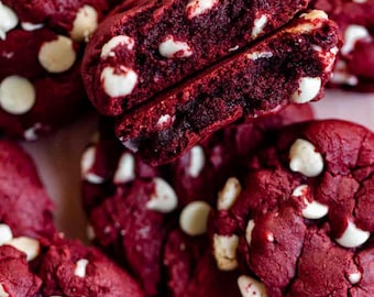 May include: Close-up of red velvet cookies with white chocolate chips. The cookies are soft and chewy, and the white chocolate chips are melted and gooey.