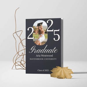 May include: A dark blue graduation announcement with a white border. The announcement features a photo of a graduate wearing a cap and gown, the year 2025, the word "Graduate" in a script font, the name "Aria Westwood", and the text "HAVENBROOK UNIVERSITY" and "Class of 2025".