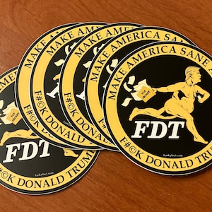 May include: A set of five round stickers with a black background and a yellow border. The stickers feature a cartoon image of a nude man running with a bag of papers labeled "Top Secret". The text on the stickers reads "Make America Sane Again" and "FDT F#OK Donald Trump".