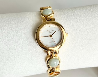 Vintage Mainline Women’s Watch: Round White Dial, Green Gemstones, Gold Tone