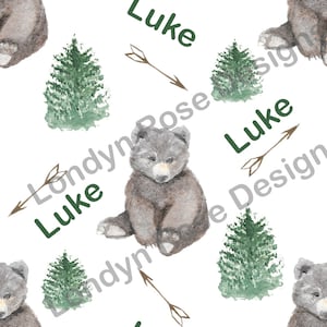 Peut inclure: Un motif sans couture représentant une illustration aquarelle d'un ourson brun, un pin vert et le nom "Luke" écrit en vert avec une flèche pointant vers la droite. Le motif se répète sur un fond blanc.