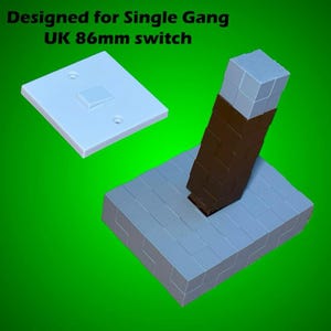 May include: A light grey, block-style base with a brown and grey structure rising from it, and a white switch plate. The text "Designed for Single Gang UK 86mm switch" is at the top.