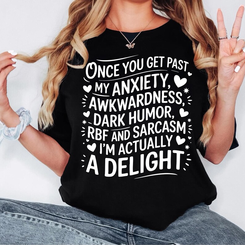 May include: Black t-shirt with white text that reads "Once you get past my anxiety, awkwardness, dark humor, RBF and sarcasm I'm actually a delight".