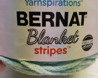 May include: A skein of Bernat Blanket Stripes yarn in a light blue and green colorway. The yarn is labeled "Yarnspirations" and "Bernat Blanket Stripes" with a Jo-Ann Fabrics exclusive label.