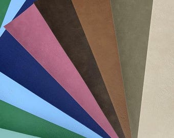 May include: A collection of eight different colored faux leather sheets. The sheets are arranged in a fan shape, with the lightest color at the top and the darkest color at the bottom. The colors are: beige, olive green, brown, dark brown, pink, navy blue, light blue, and green.