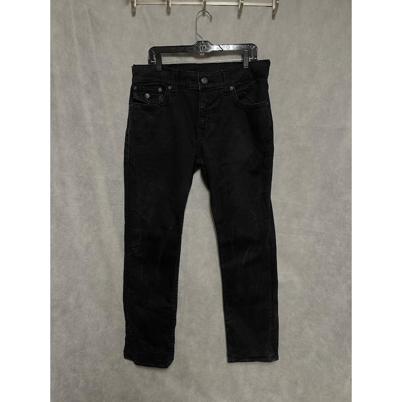 Calça jeans True Religion masculina, tamanho 33x33, preta, modelo Ricky, corte reto e modelagem relaxada, com elastano e bolsos com aba. imagem 2
