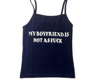 May include: Navy blue camisole tank top with thin straps. The white text on the front reads "MY BOYFRIEND IS HOT AS FUCK". The bottom of the tank top has the text "@deanyndreamzrus".