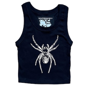 May include: Black crop top with a white spider graphic. The tank top has a scoop neck and a cropped fit. The text "DECAYEDCEREBRUM" is printed on a small label at the top.