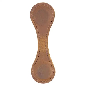 Puede incluir: Un marcap&aacute;ginas de cuero marr&oacute;n con un borde cosido y una forma redondeada.