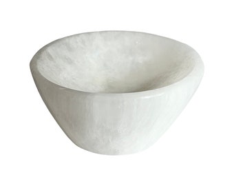 May include: A white, cone-shaped bowl with a smooth, polished exterior. The bowl's interior has a textured, cloudy appearance. The bowl is made of a solid, opaque material, and is suitable for decorative or functional use.