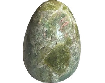 May include: A green and white egg-shaped polished stone with pink and white swirls.