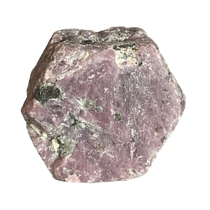 Puede incluir: Un gran cristal de rubí rosa en bruto con forma hexagonal. El cristal tiene un color rosa oscuro con algunas inclusiones negras y blancas.