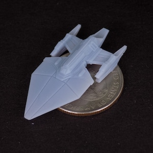 May include: A white plastic model of a spaceship, about the size of a US quarter.