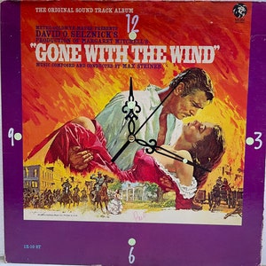 May include: A vintage clock featuring a scene from the movie "Gone With The Wind" with the text "The Original Sound Track Album" and "Metro-Goldwyn-Mayer Presents David O. Selznick's Production of Margaret Mitchell's Gone With The Wind" and "Music Composed and Conducted by Max Steiner".