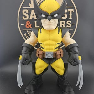 May include: A stylized figurine of a character wearing a yellow and black suit with a mask featuring pointed ears. The figure has black gloves with three silver claws extending from each hand, a brown utility belt with a silver X buckle, and black boots.