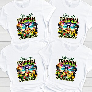 May include: Four white t-shirts with a colorful graphic design. The design features sunglasses reflecting a beach scene, a cocktail, and the words "Straight Trippin' Jamaica" in a vibrant font. The shirts are made of a soft, breathable material.