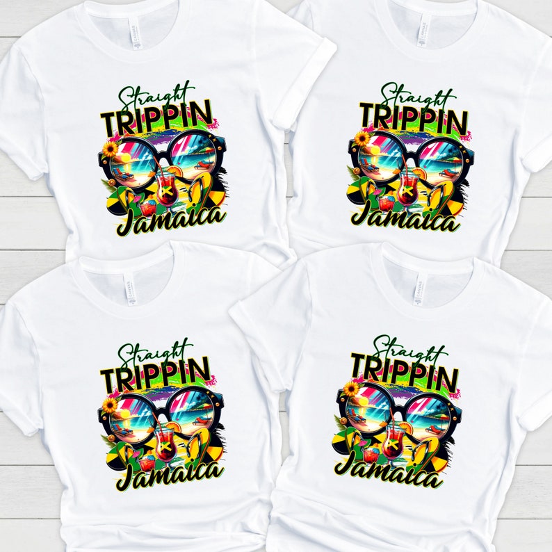 May include: Four white t-shirts with a colorful graphic design. The design features sunglasses reflecting a beach scene, a cocktail, and the words "Straight Trippin' Jamaica" in a vibrant font. The shirts are made of a soft, breathable material.
