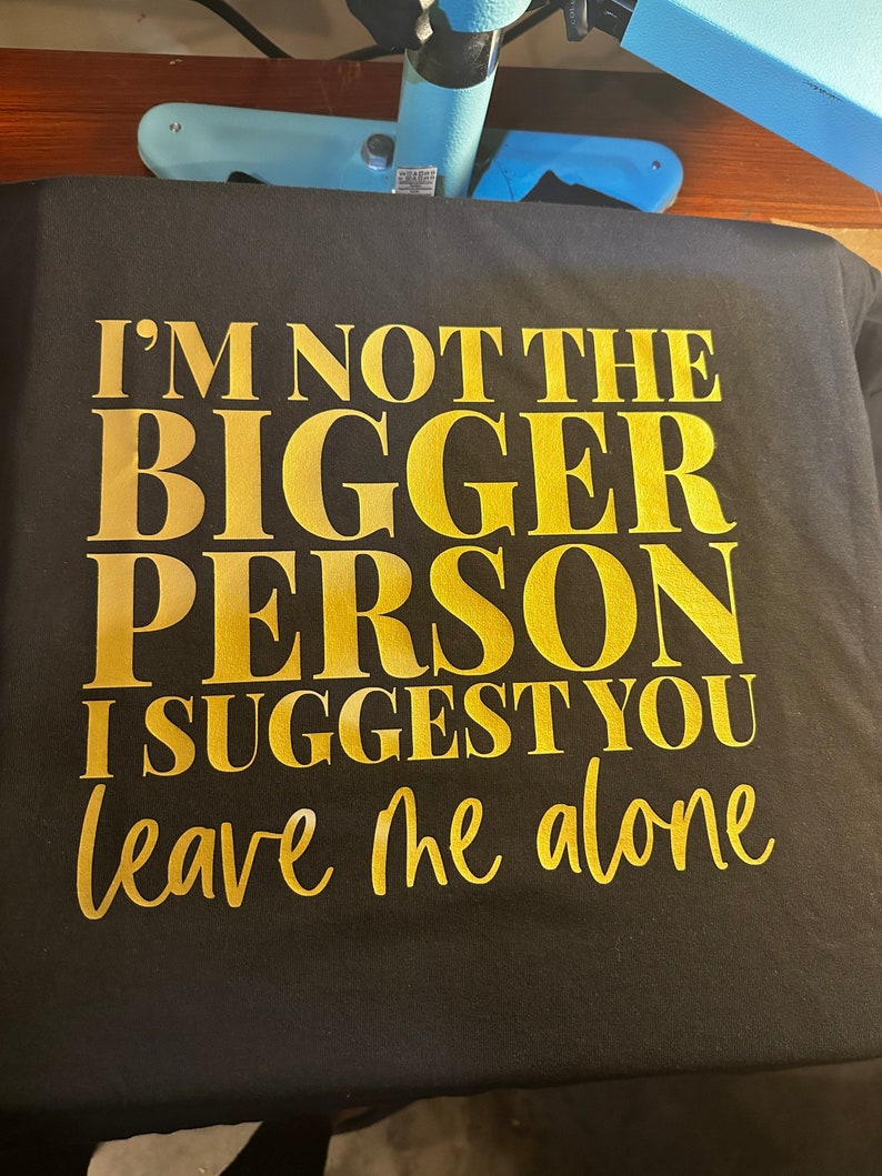 May include: Black t-shirt with gold lettering that reads "I'm not the bigger person I suggest you leave me alone."