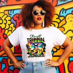 May include: White t-shirt with a colorful graphic design featuring sunglasses, a beach scene, and the words "Straight Trippin Jamaica." The design includes yellow, green, blue, and red elements. The shirt is worn by a person with curly brown hair and sunglasses.