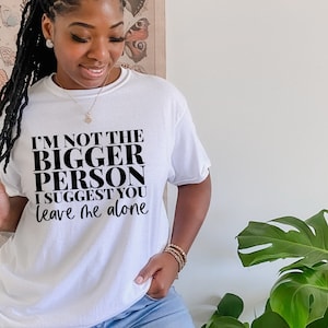 May include: White t-shirt with black text that reads "I'm not the bigger person I suggest you leave me alone."