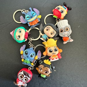 May include: A set of eight colorful character keychains featuring Disney characters like Stitch, Miguel from Coco, and Rapunzel. The keychains are made of plastic and have a 3D design.
