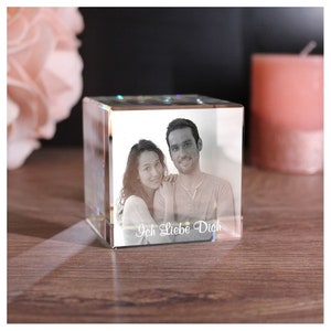 Op de afbeelding: Een transparante glazen kubus met een zwart-witfoto van een stel erin. De foto is gegraveerd in het glas en de tekst "Ich Liebe Dich" staat onder de foto.