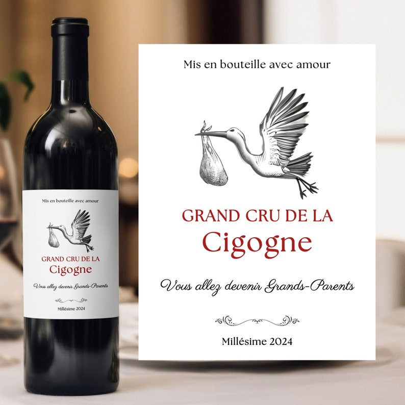May include: A bottle of wine with a label that says "Grand Cru de la Cigogne" and "Mis en bouteille avec amour". The label also features a black and white illustration of a stork carrying a baby in a bag. The text on the label says "Vous allez devenir Grands-Parents" and "Mill&eacute;sime 2024".