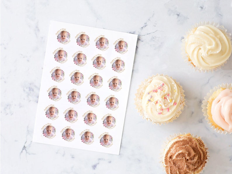 May include: A sheet of white sticker paper with 36 round stickers featuring a baby's photo in a gold frame with pink and gold hearts. The stickers are perfect for decorating cupcakes or other treats.