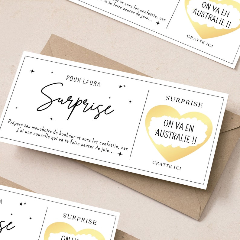 May include: A white card with black text that reads "Surprise" and "Prepare your tissues of happiness and get out the confetti, because I have news that will make you jump for joy..."  The card also has a gold heart with the text "ON VA EN AUSTRALIE!!" and the words "GRATTE ICI" below the heart.