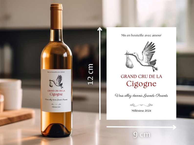 May include: A white wine bottle with a label that says "Grand Cru de la Cigogne" and "Vous allez devenir Grands-Parents" with a stork illustration. The bottle is 12 inches tall and the label is 9 inches wide.