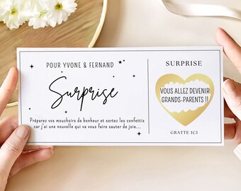 May include: A white card with a gold heart and the text "Surprise! You are going to be grandparents!"  The card also has the text "Prepare your tissues of happiness and get out the confetti because I have news that will make you jump for joy..." and "Scratch here".