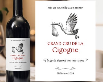 May include: A white wine bottle label with a black and white illustration of a stork carrying a baby in a bag. The label says "Grand Cru de la Cigogne" and "Veux-tu devenir ma marraine?" with the year "Millésime 2024".