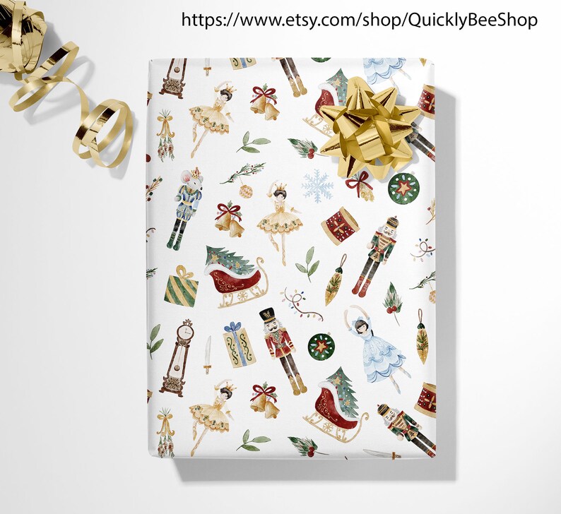 May include: White wrapping paper with a repeating pattern of Christmas-themed illustrations. The illustrations include a nutcracker, a ballerina, a sleigh, a Christmas tree, and a clock. The paper is decorated with gold, red, green, and blue colors.