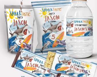 May include: Shark-themed party favour labels featuring a blue and white striped background with a shark, waves, and a surfboard. The labels are for juice boxes, water bottles, and snack bags. The text on the labels reads "Sharktastic Party Jason is turning 5".
