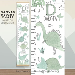 Puede incluir: Un medidor de altura de lona con un tema de dinosaurios. El gráfico presenta una ilustración de dinosaurio verde claro, el nombre "Dakota" y una escala de medición en centímetros. También es visible el texto "Canvas Height Chart".