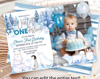 May include: A blue and white winter wonderland themed first birthday invitation with a photo of a baby boy holding a cake. The invitation features a polar bear, penguin, walrus, and arctic fox. The text on the invitation reads "Join us in a Winter Wonderland One to celebrate Ethan's First Birthday Saturday 04.18. at 1:00 p.m. Sophia's House 123 Street Name, City Name State, Country 12345 RSVP to Mom Sophia 123-456-7890 You can edit the entire text!"